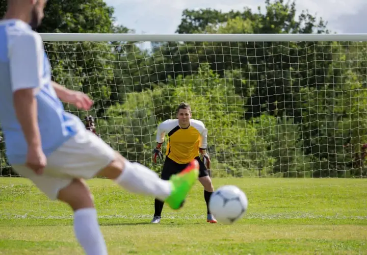 Piłkarz strzela do bramki, bramkarz gotowy. Czy to będzie hattrick?