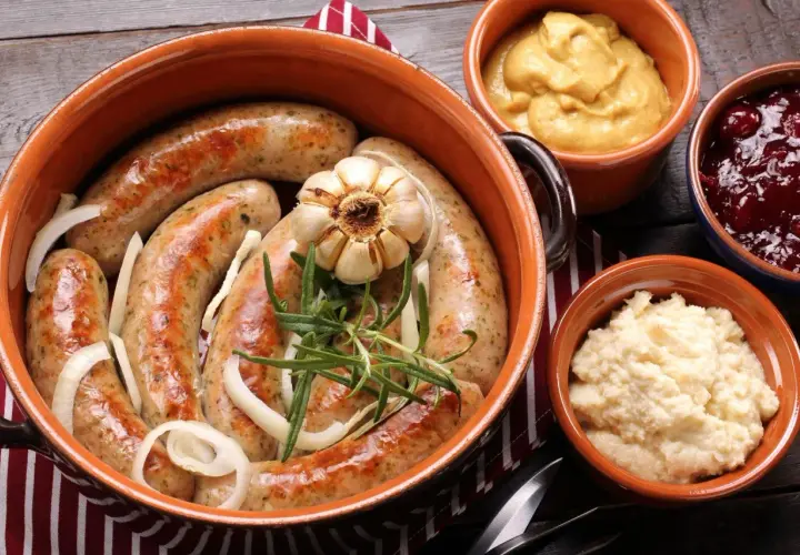 Pyszna biała kiełbasa pieczona w cebuli i musztardzie, podana z chrzanem i żurawiną.