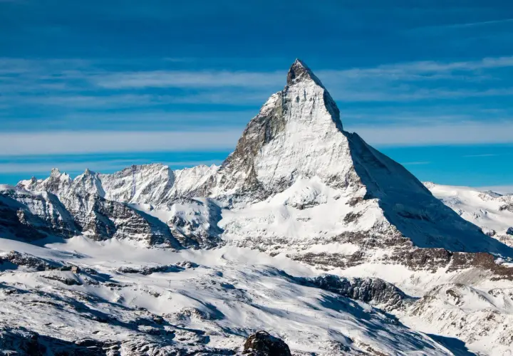 Majestatyczny Matterhorn w śnieżnej szacie, zapraszający do wejścia na szczyt.