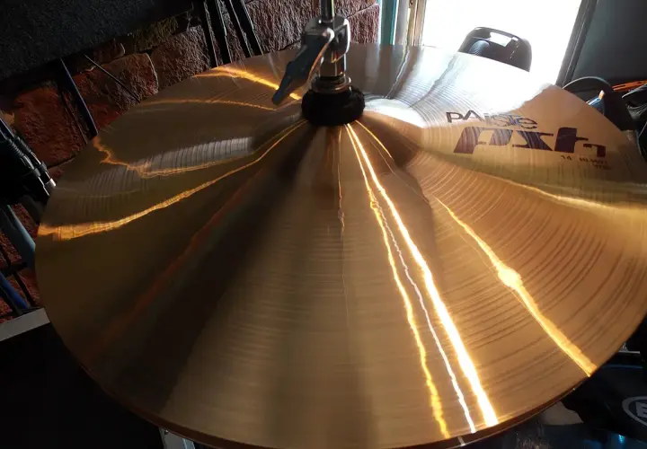 Błyszczące, złote talerze Paiste FX, instrument perkusyjny, odbijają światło, gotowe do rytmicznego uderzenia.