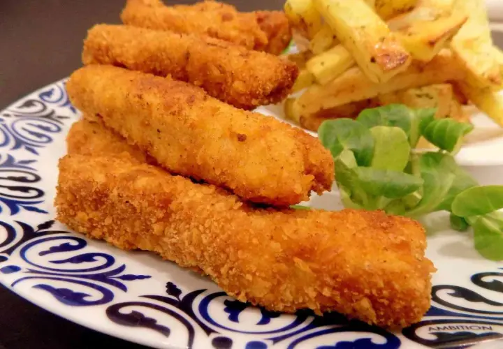 Chrupiące paluszki rybne lub kurczak w panierce, podane z frytkami i sałatką. Idealne na szybki obiad.