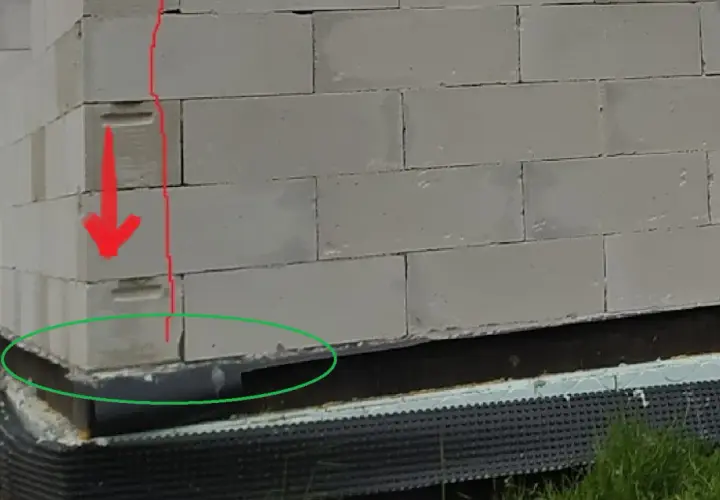 Widoczne trzpienie żelbetowe w ścianach murowanych z bloczków betonowych, wzmocnienie narożnika.