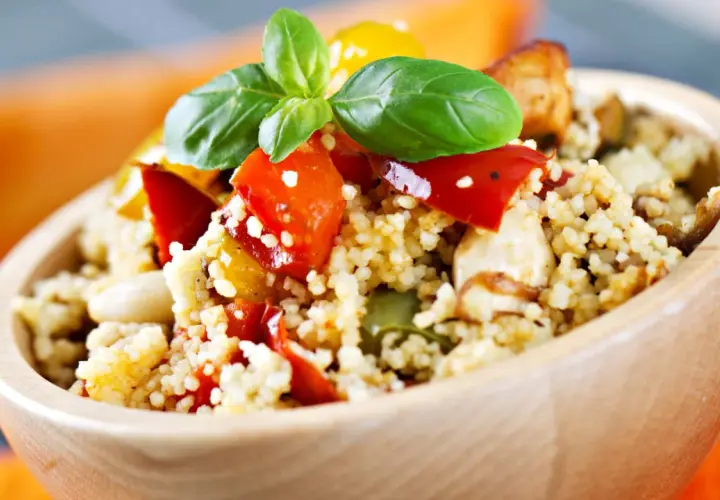 Ciotola di couscous con verdure colorate e basilico, perfetta per le ricette svezzamento 6 mesi.