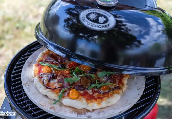 Selbstgemachte Pizza auf einem Pizzastein im Outdoorchef Grill. Die Frage ist nur, wieviel Grad im Ofen für den perfekten Biss?
