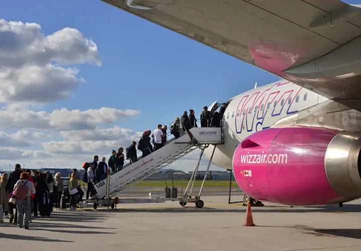Pasażerowie wsiadają po schodkach do samolotu Wizz Air.
