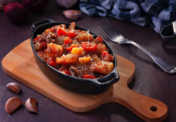 Plat mijoté de crevettes et tomates, garni de parmesan. Idéal pour apprendre comment dégraisser un plat et le rendre savoureux.