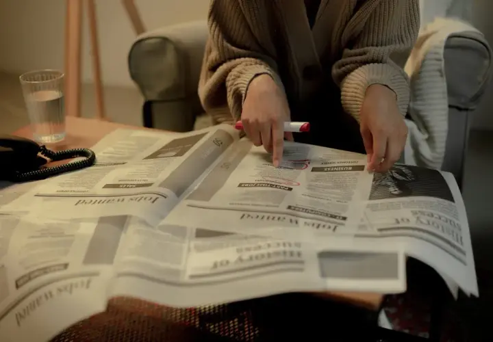 Osoba przegląda ogłoszenia o pracę, szukając informacji o jawności wynagrodzeń.