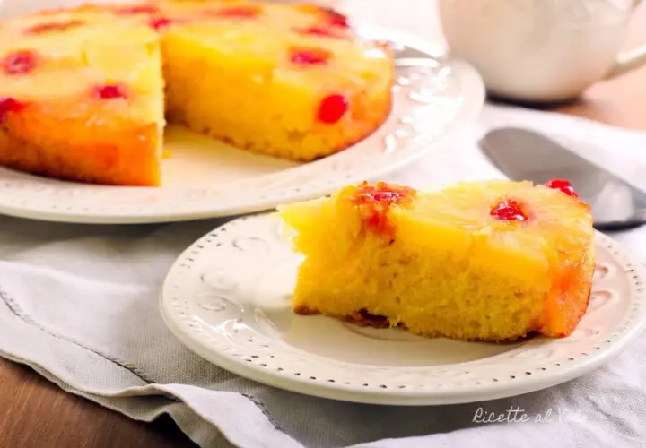 Una fetta di torta ananas, con la sua base dorata e la copertura di frutta caramellata, pronta per essere gustata.