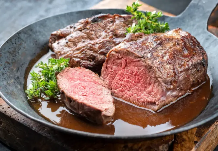 Un rôti de chevreuil juteux, coupé en tranches, baignant dans une sauce savoureuse. Un plat qui invite à se demander quel vin avec du chevreuil serait le meilleur accord.