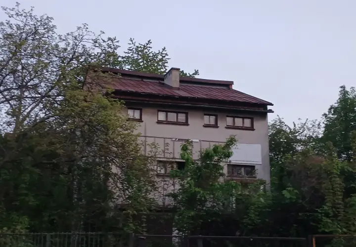 Stary, zaniedbany budynek otoczony drzewami, który według legend jest najbardziej nawiedzonym domem w Polsce.
