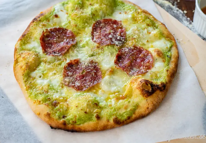 En pizza bianco med salami, ost och grön sås.