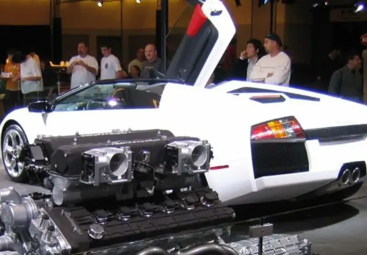 Biały Lamborghini Murcielago z otwartymi drzwiami i wyeksponowanym potężnym silnikiem V12.