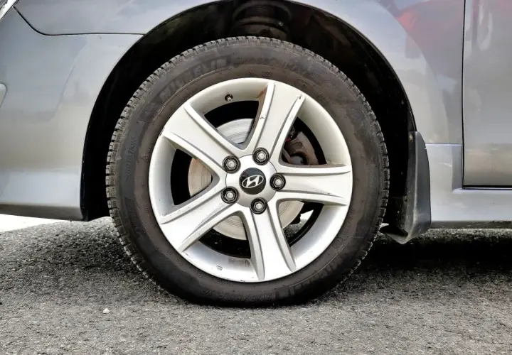 Koło samochodu z widocznym niskim ciśnieniem w oponach. Felga aluminiowa z logo Hyundai.