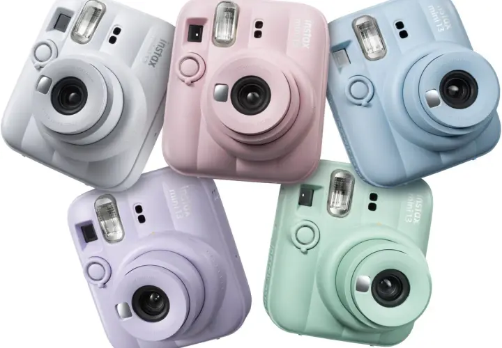 Pięć aparatów Instax Mini 13 w pastelowych kolorach: białym, różowym, niebieskim, fioletowym i miętowym.