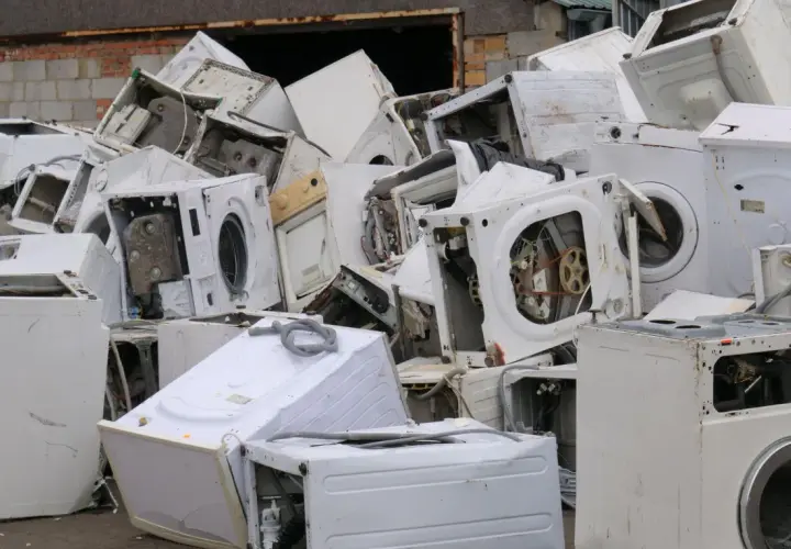 Góra złomu ze starymi pralkami. Zastanawiasz się, co zrobić ze starą pralką? Tutaj znajdziesz odpowiedź – to miejsce na recykling.