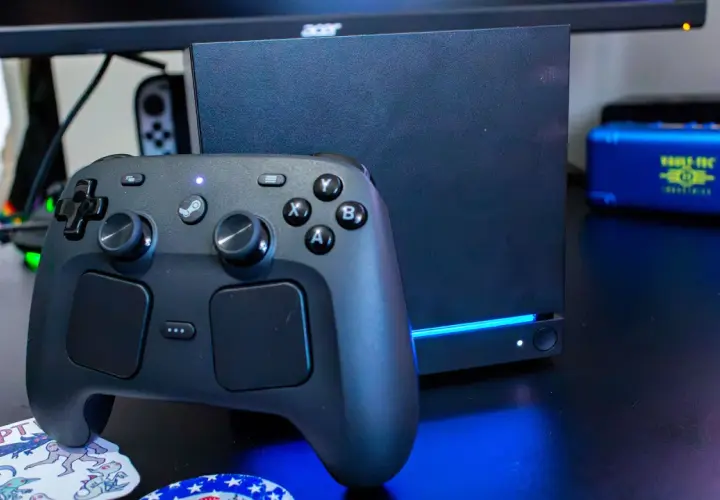 Ein schwarzer Steam Controller 2 liegt vor einem dunklen Gaming-PC.