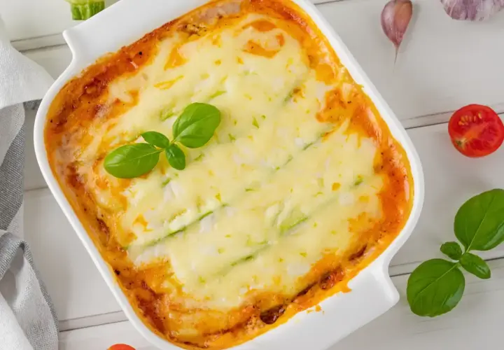 Lasagnes de courgettes sans pâtes, gratinées et dorées, garnies de basilic frais. Un délice léger et savoureux.