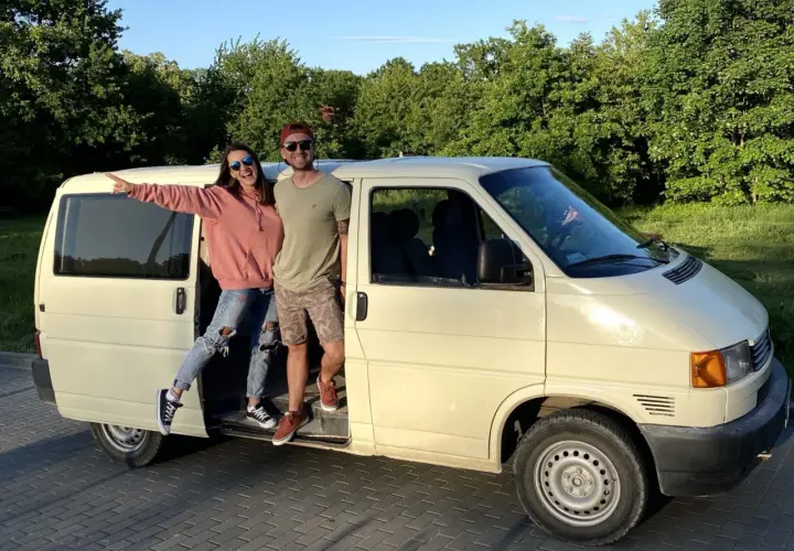 Para młoda pozuje przy swoim t4 camperze, gotowa na przygodę.