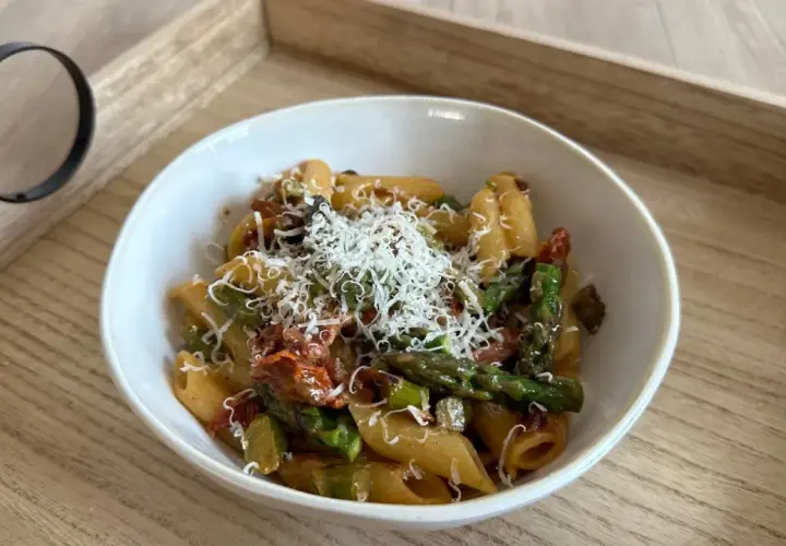 Penne z zielonymi szparagami i suszonymi pomidorami w kremowym sosie, posypane parmezanem. Pyszny makaron ze szparagami w sosie śmietanowym.