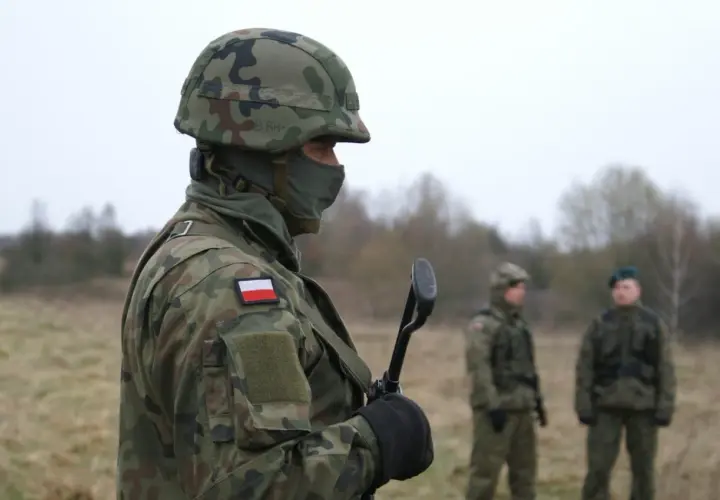 Żołnierz w kamuflażu, z polską flagą na ramieniu, gotowy do służby. Czy to zapowiedź podwyżki w wojsku w 2026 roku?