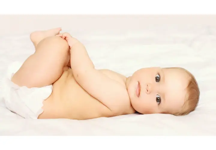 Bambino con pannolino, gambe sollevate, pronto per un cambio per prevenire la candida da pannolino.