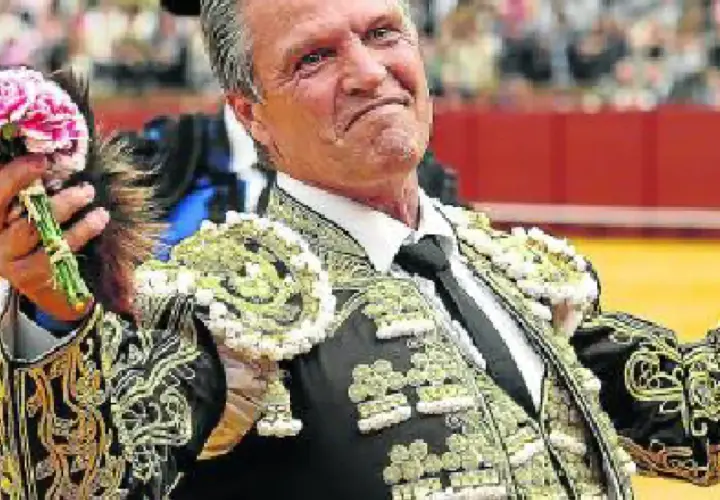 Juan Antonio Ruiz Espartaco, torero con traje de luces, ofrece un ramo de flores al público.