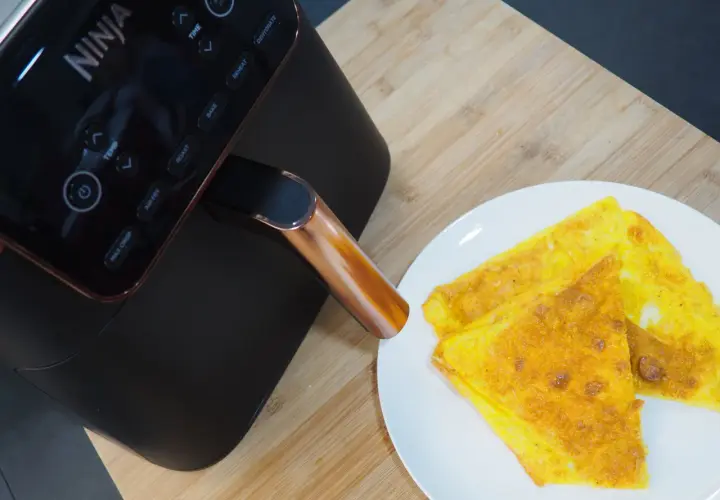 Frittata dorata appena sfornata dalla friggitrice ad aria Ninja, pronta per essere gustata.