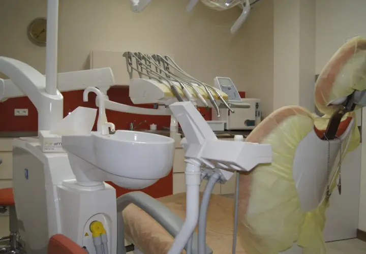 Nowoczesny gabinet stomatologiczny z fotelem dentystycznym i narzędziami.
