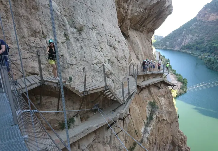 Wagemutige genießen das Malaga Wandern auf dem Caminito del Rey, einem Pfad an steilen Felswänden über einem Fluss.