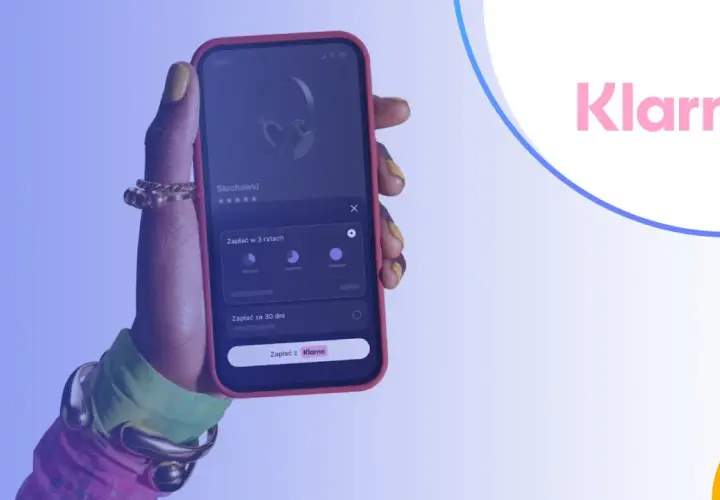 Dłoń trzymająca telefon z aplikacją Klarna, pokazującą opcje płatności za słuchawki.