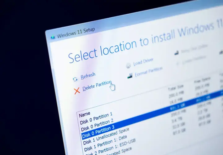 Instalacja Windows 11. Ekran wyboru lokalizacji, gdzie widać opcję "Usuń partycję". To nie jest defragmentacja dysku Windows 10, lecz przygotowanie do instalacji.