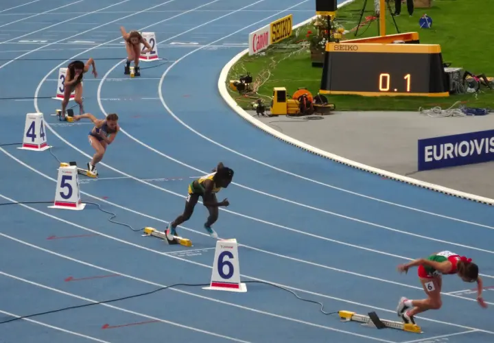Biegaczki na 400 m, jedna z nich w zielono-żółtym stroju, walczy o rekord Polski.