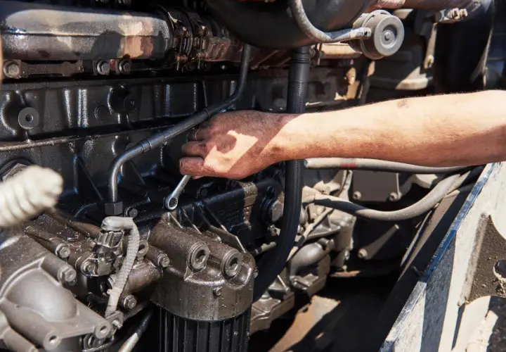 Mano che lavora su un motore, forse per riparare l'alternatore auto.