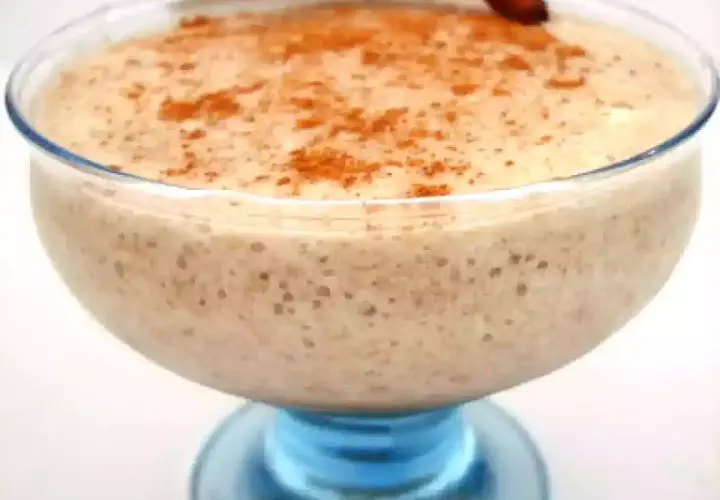 Un déliceux mousse banane crémeuse, saupoudrée de cannelle, servie dans un joli bol en verre bleu.