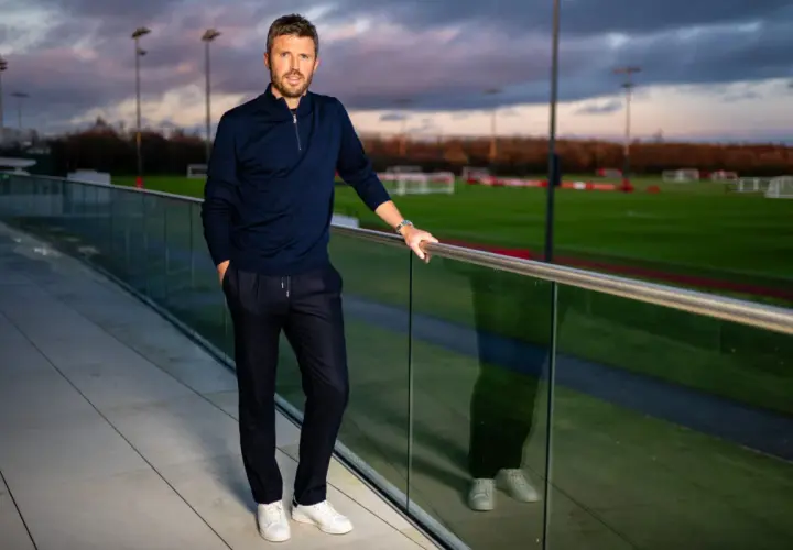 Michael Carrick, jeden z trenerów Man Utd, pozuje na tle boisk treningowych.