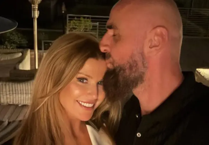 Marcin Gortat całuje swoją żonę w czoło. Para cieszy się wieczorem na tarasie.
