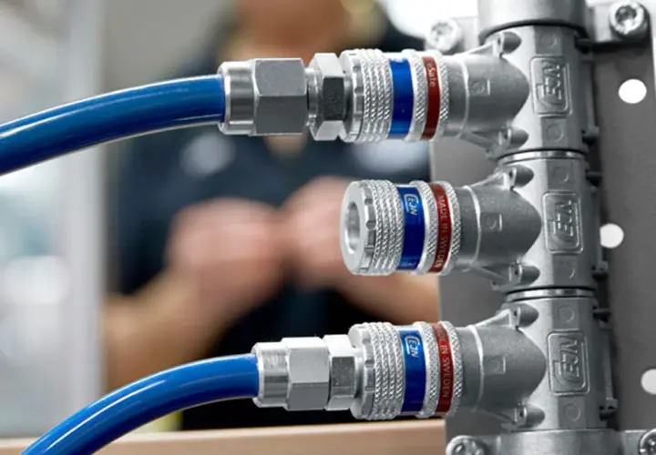 Conexiones rápidas de gas con rosca cónica, azules y plateadas, con detalles rojos y azules.