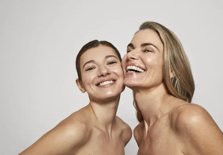 Dos mujeres sonríen, sus rostros radiantes y piel luminosa, un reflejo de la confianza que brinda Oslo Skin Lab.