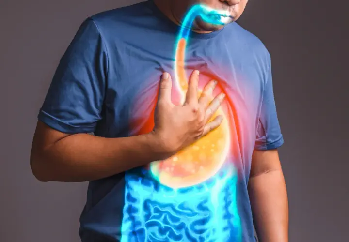 Uomo con mano sul petto, evidenziando il reflusso gastroesofageo e i sintomi legati all'ansia.