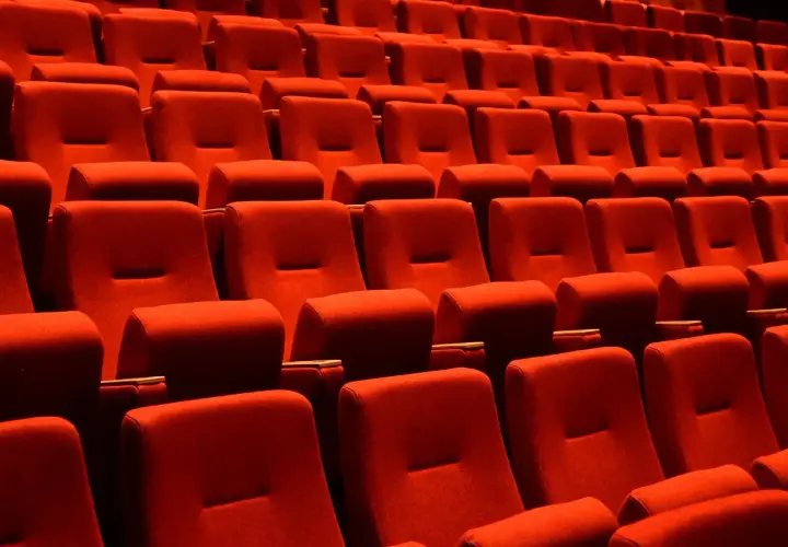 Czerwone fotele kinowe, idealne do oglądania filmów. Które miejsca w teatrze są najlepsze? Te z najlepszym widokiem i dźwiękiem!