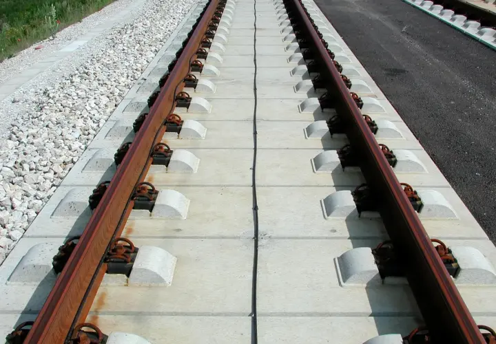 Nowe podkłady betonowe pod torami kolejowymi, gotowe na przyjęcie pociągów.