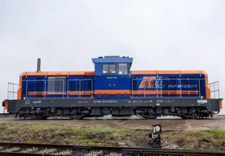 Niebiesko-pomarańczowa lokomotywa SM42 PKP Intercity SU4220-002 stoi na torach.