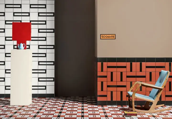 Un soggiorno moderno con pavimenti geometrici. Una poltrona a dondolo blu e legno, un piedistallo con una lampada rossa e una teiera blu.
