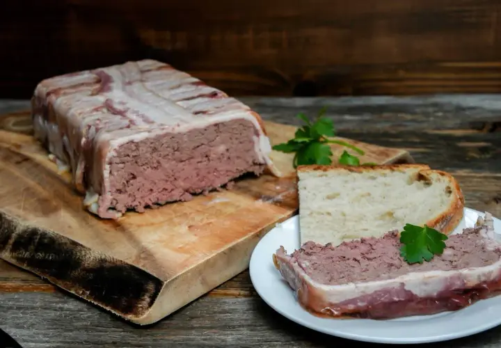 Pate zawinięte w boczek, pokrojone na talerzyku z chlebem. Pyszne pate, idealne na przekąskę.