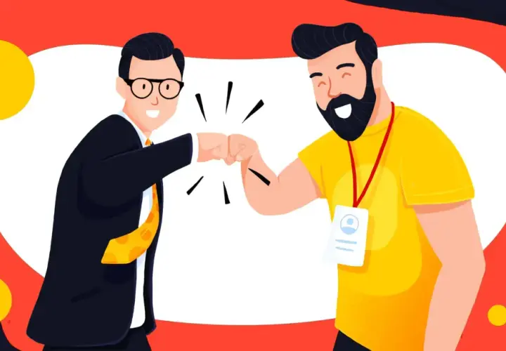 Dwóch mężczyzn w garniturze i żółtej koszulce wykonuje "fist bump" na tle czerwono-białym z żółtymi kołami.