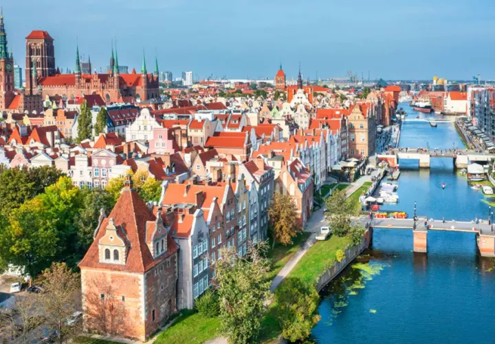 Widok na starówkę Gdańsk z kanałem Motławy, mostami i zabytkowymi kamienicami.