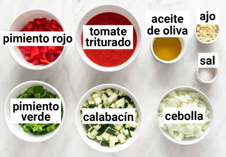 Ingredientes para hacer pisto: pimiento rojo, pimiento verde, calabacín, tomate triturado, cebolla, ajo, aceite de oliva y sal.