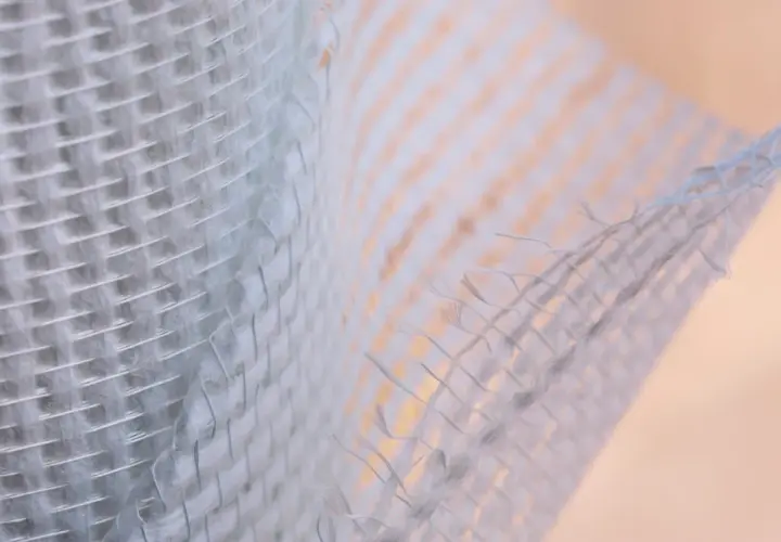 Trama di **rete fibra di vetro rinforzo strutturale**, con fili intrecciati che creano una texture robusta e flessibile, ideale per consolidamenti.
