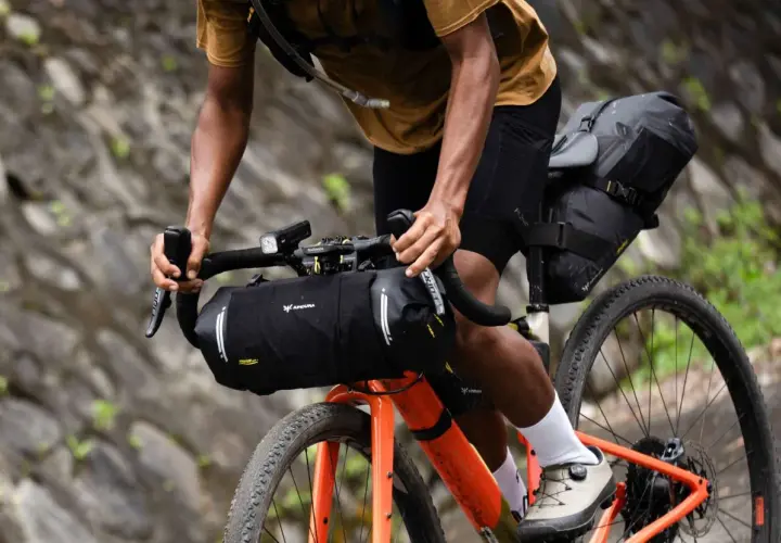 Ciclista en ruta de bikepacking carretera, con alforjas y equipo listo para la aventura.