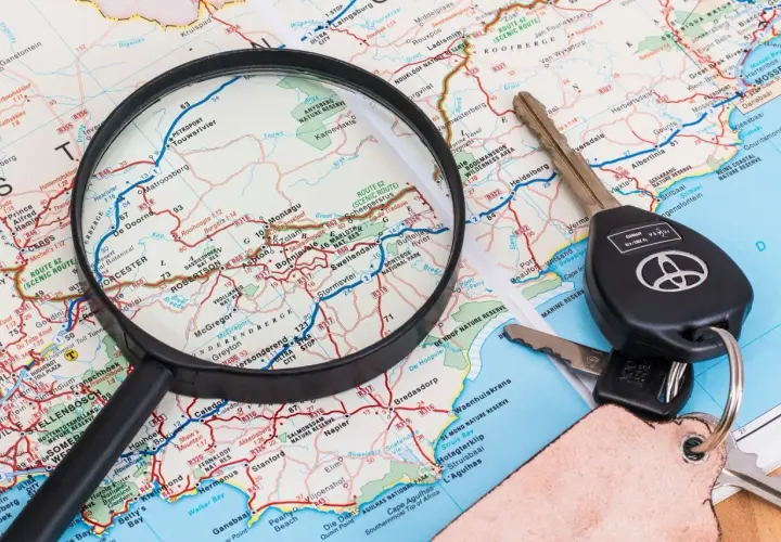 Planowanie trasy z ViaMichelin: lupa nad mapą, kluczyki samochodowe i brelok.